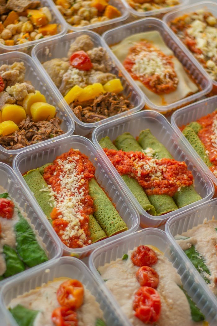 ours-journey An assortment of healthy, colorful meal prep boxes featuring vegetables, grains, and proteins.