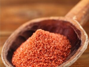 Red spice on wooden spoon